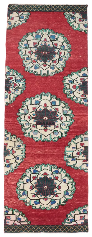 Full overhead view of the vintage Anatolian runner rug with red field and geometric medallions.
