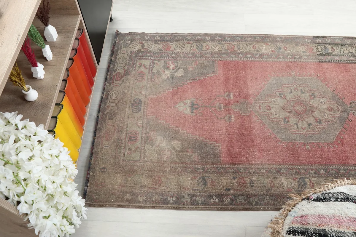 Angled view of the rug's rose field and gray border, showcasing the distressed texture.