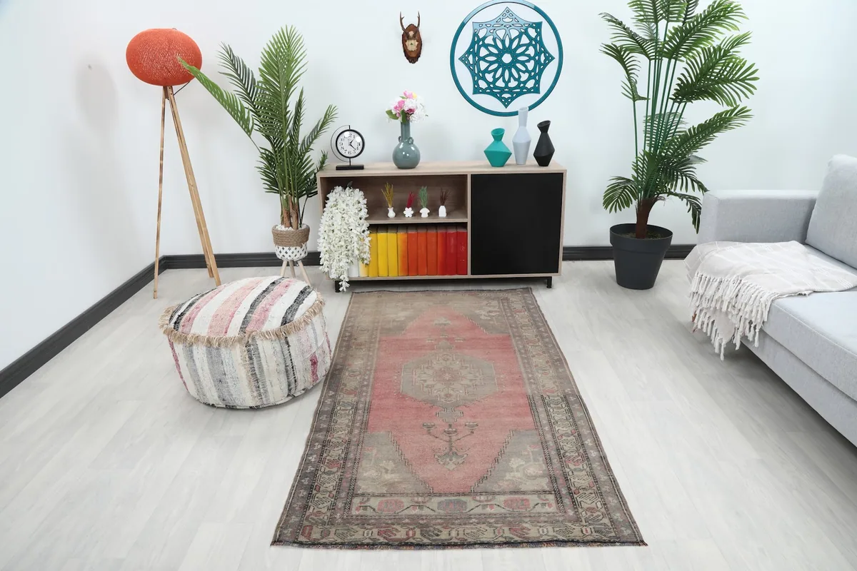 Vintage rose and gray Anatolian rug displayed in a modern living space with furniture.
