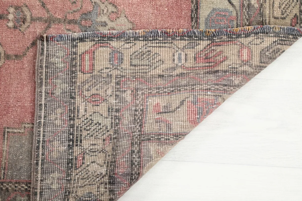 Close-up of the back of the rug, revealing the hand-knotted construction and fringe.
