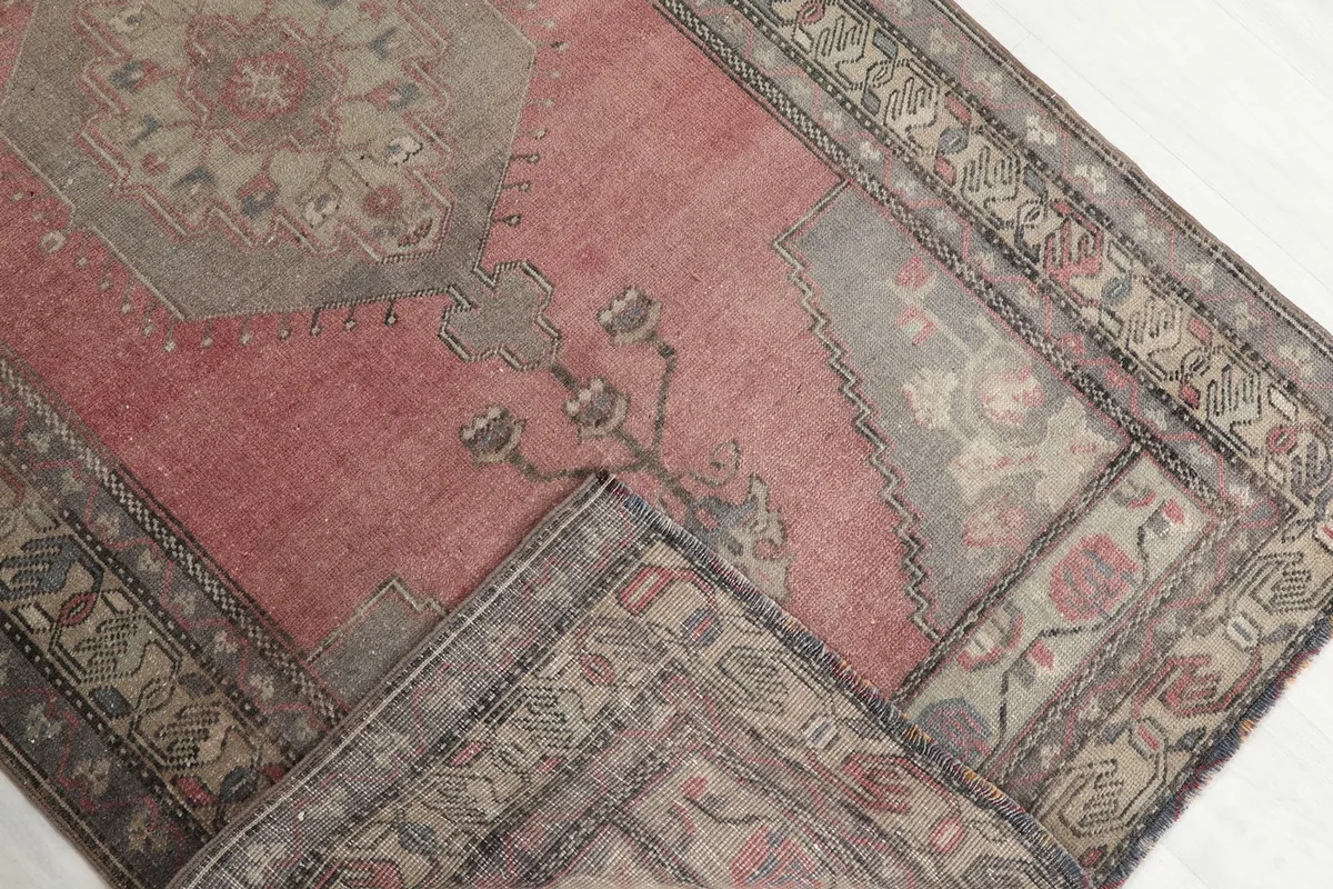 Folded section of the rug showing the wool pile and cotton foundation from an overhead perspective.