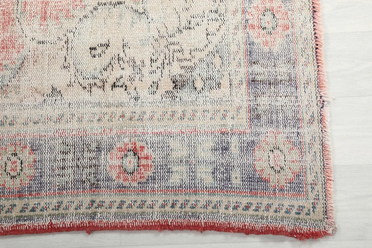 Detail of the rug's corner showing the blue and ivory border with floral motifs
