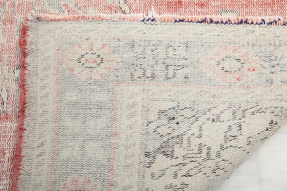 Detail of the rug's underside, showing the hand-knotted construction and fringe