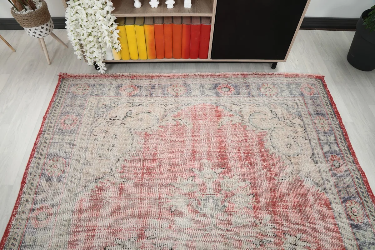 Overhead view focusing on the upper half of the rug, showing the faded pattern