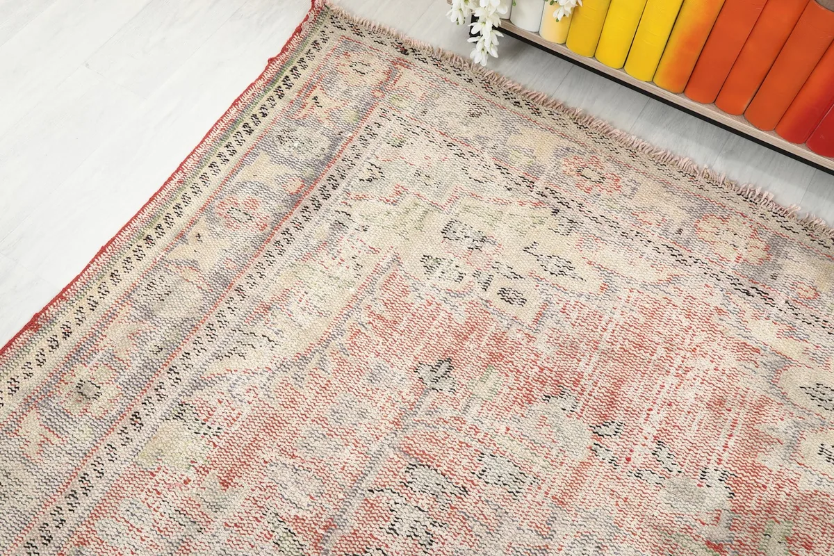 Corner view of the rug, showing the border and main field with its characteristic patina.