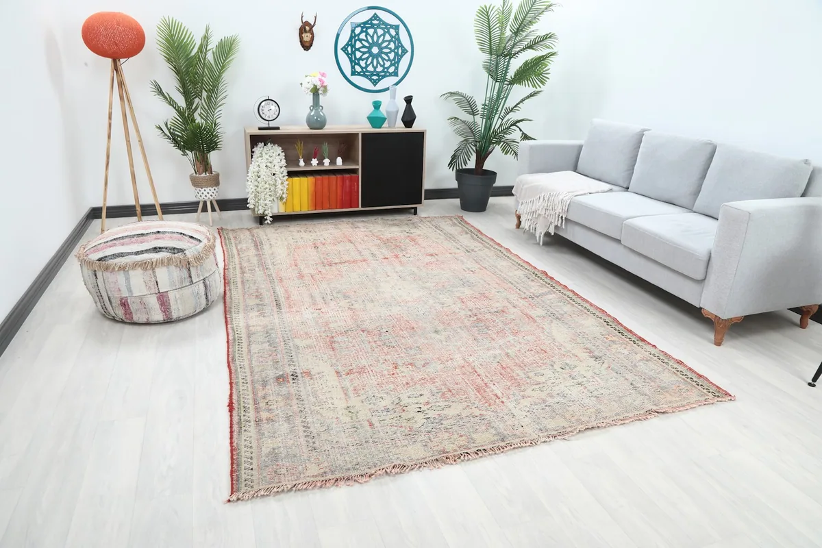 Angle view of the ivory and red rug in a room, showing its placement relative to furniture.