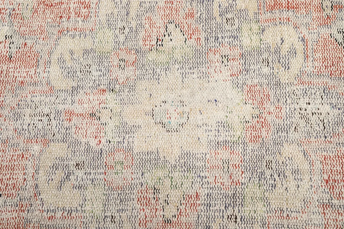 Detailed overhead shot showing the texture and faded motifs of the vintage rug.