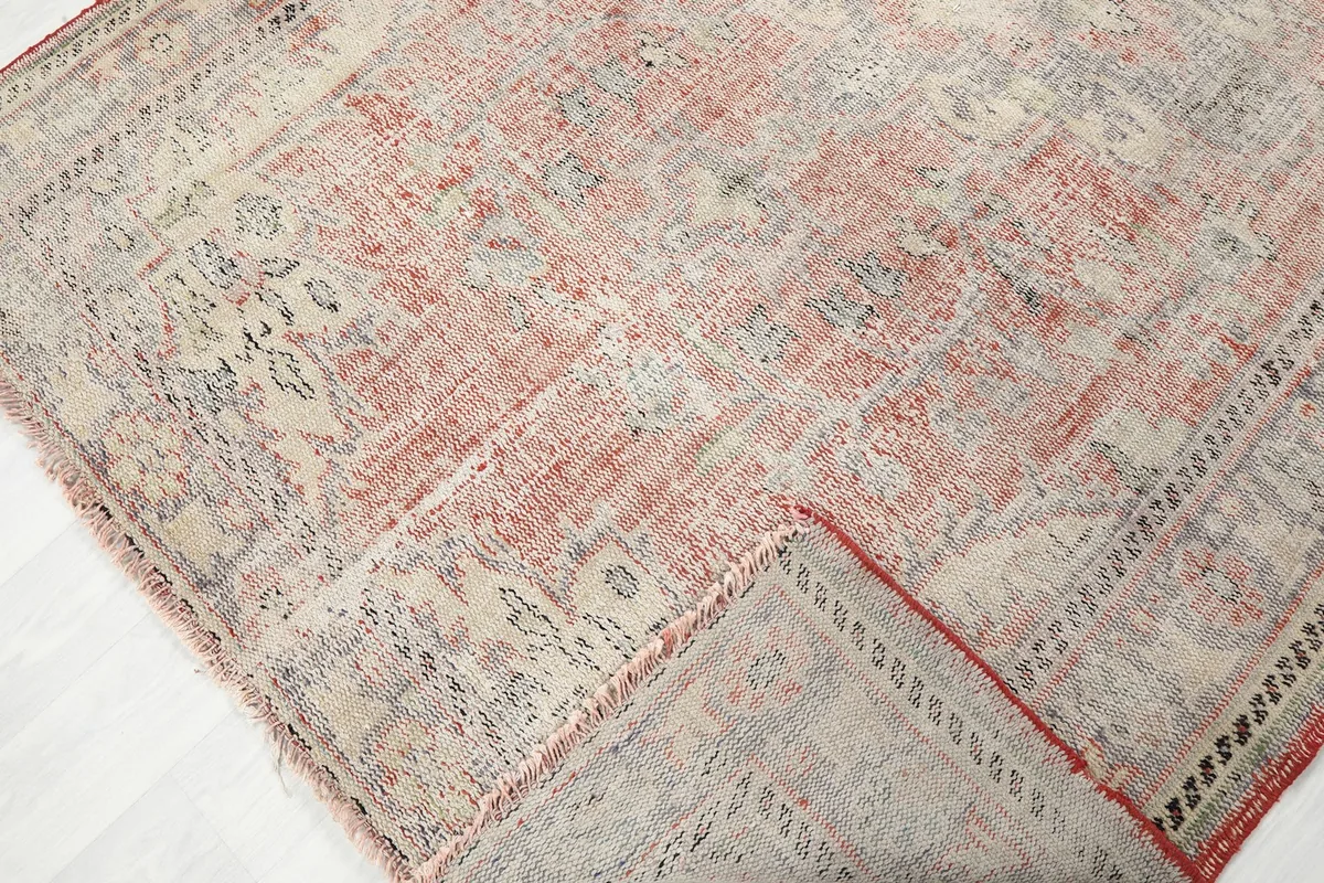 Folded corner of the rug, revealing the cotton foundation and the reverse side.