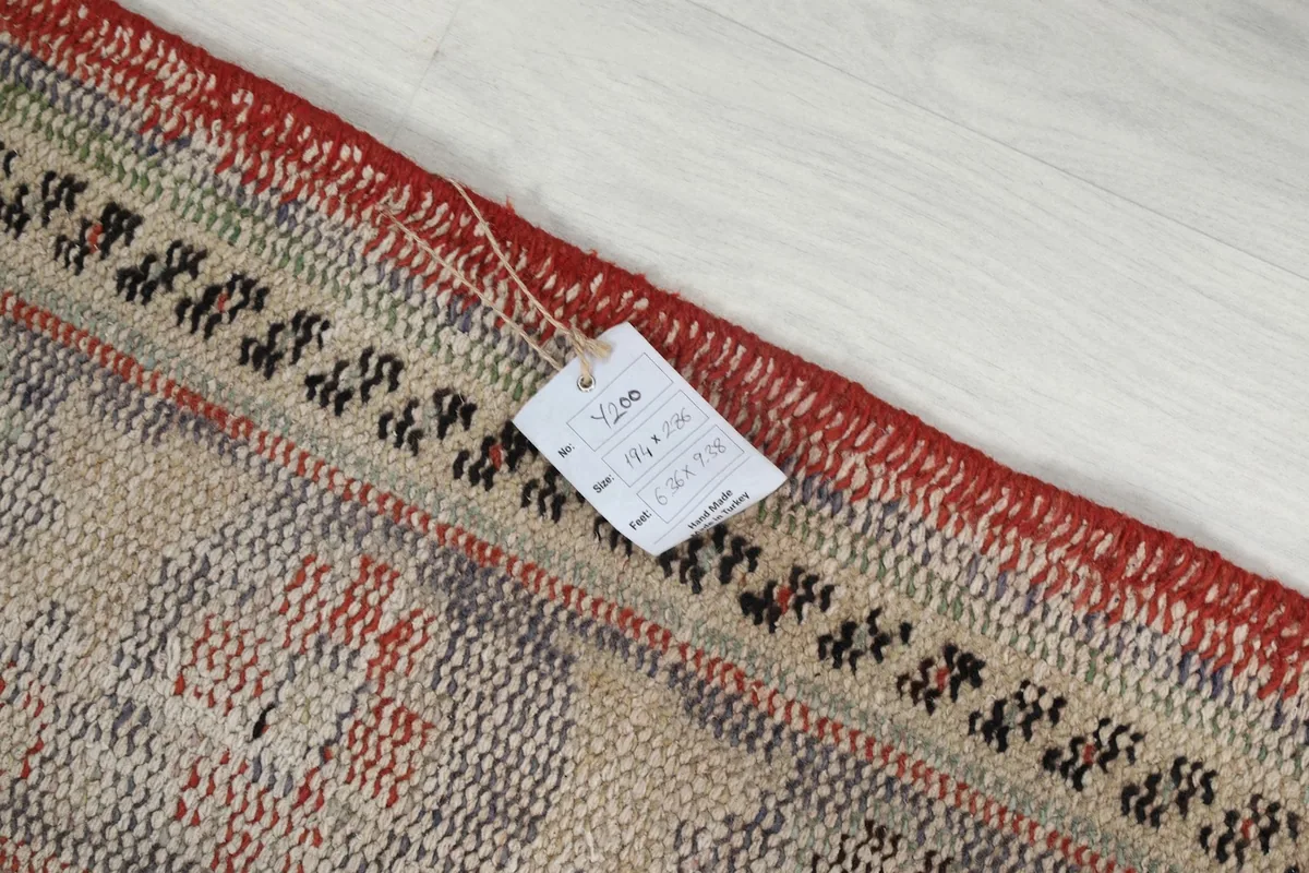 Detail of the rug's edge with a product tag, indicating its origin and material.