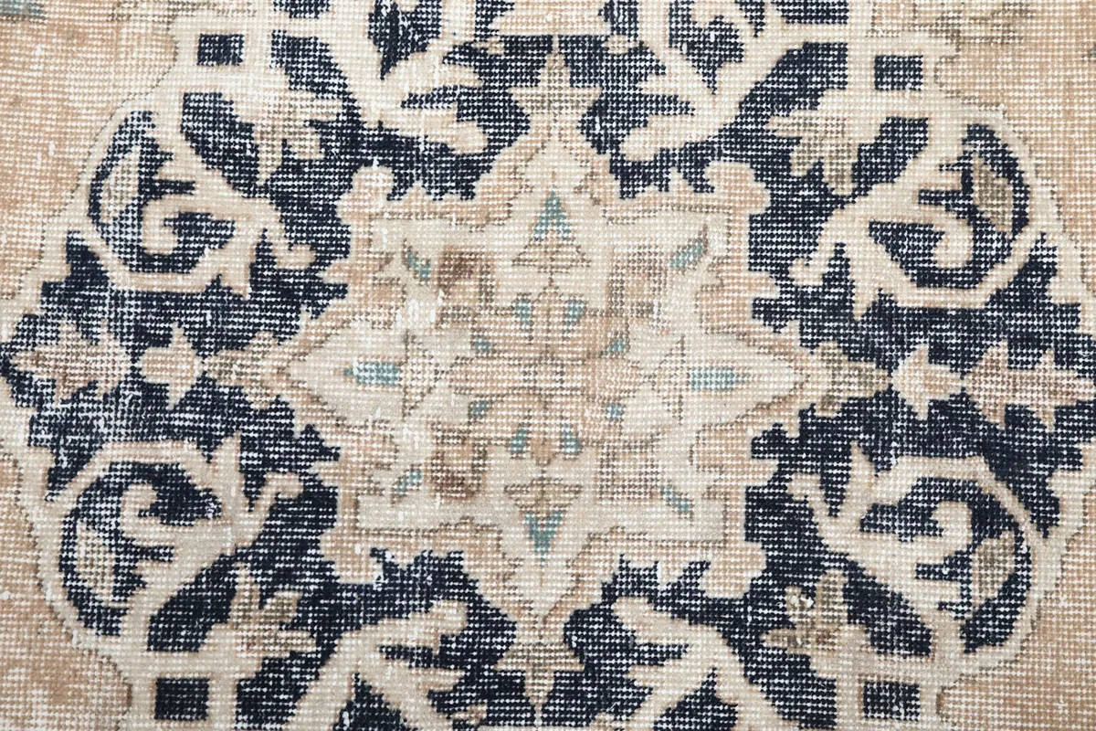 Close-up of the intricate navy and cream medallion design with subtle wear