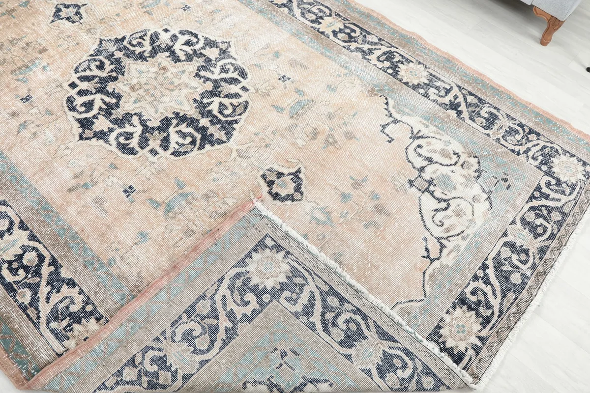 Folded corner of the rug revealing the cotton foundation and reverse side of the knotting