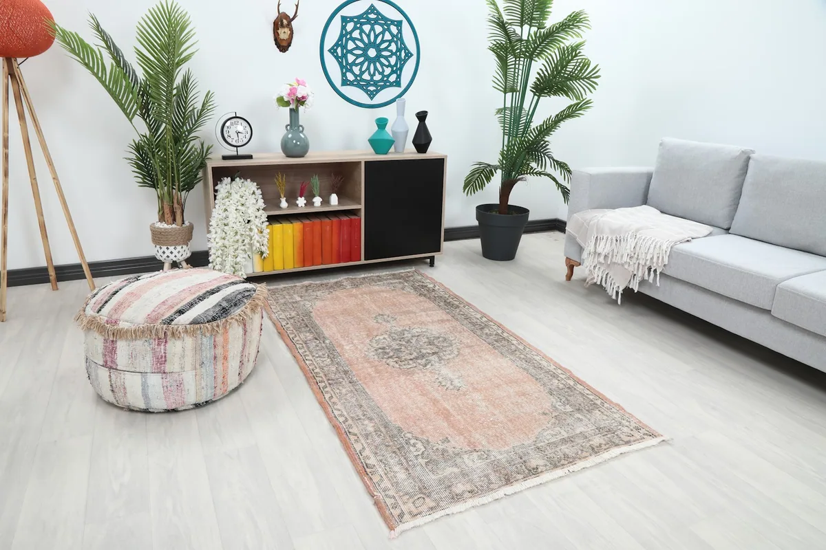 Angle view of the rose and gray Anatolian rug placed in a bright room with light flooring
