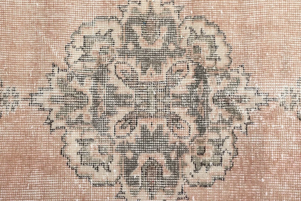 Close-up of the central gray medallion with intricate geometric motifs and wool texture