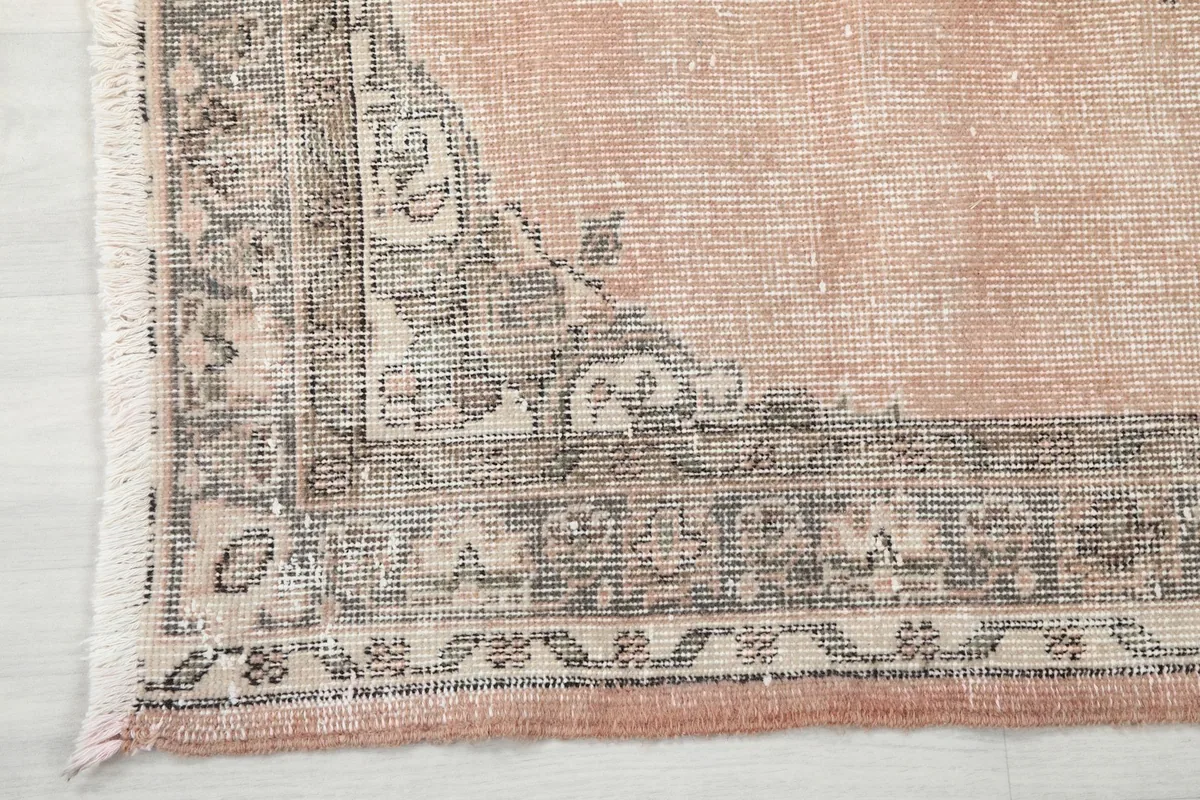 Close-up detail of the gray and beige geometric border pattern of the rug