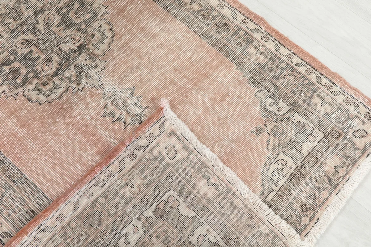 Folded corner of the rug revealing the thickness of the wool pile and cotton foundation