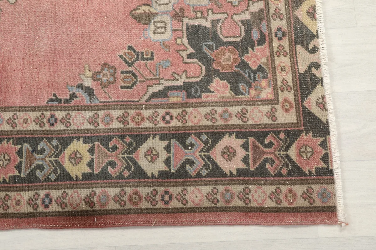 Detailed view of the intricate geometric border pattern in charcoal and beige