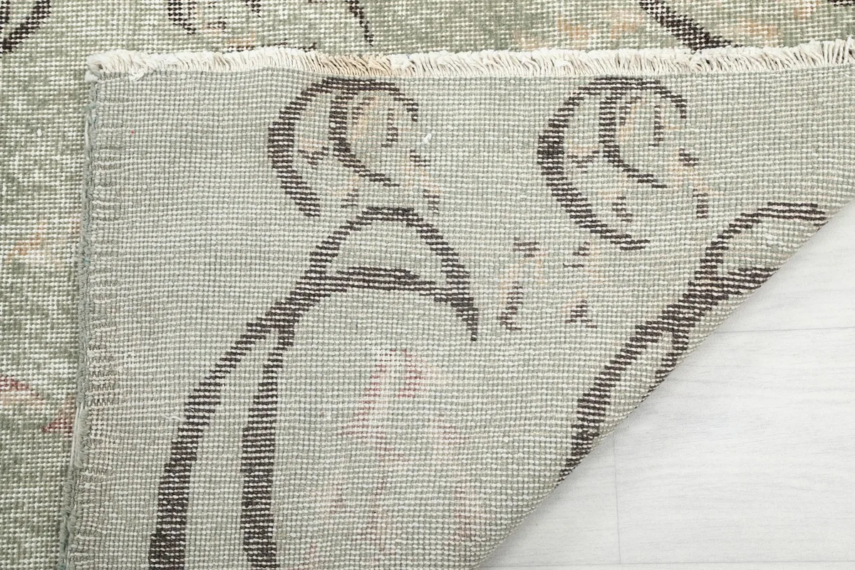Close-up of the rug's back, showing the cotton foundation and the reverse of the hand-knotted wool pile.