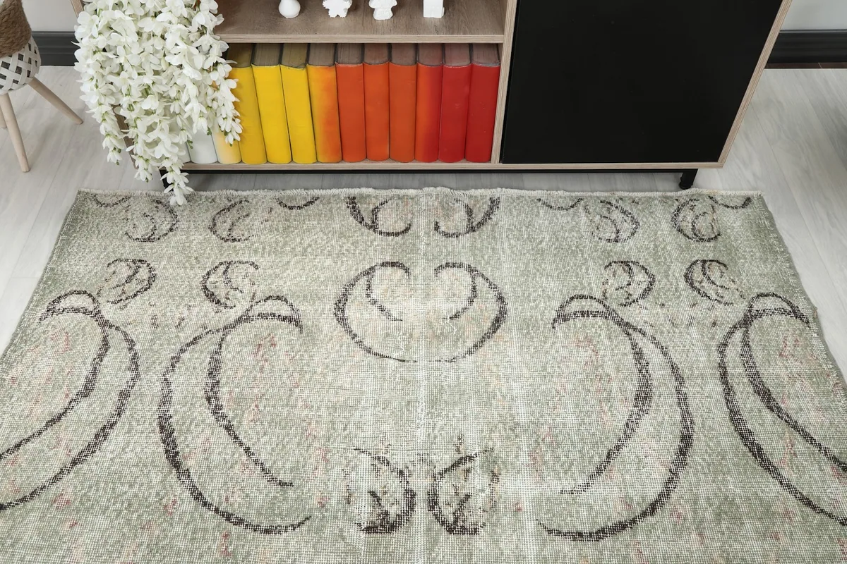 Overhead shot capturing the central and upper portion of the green vintage rug, showcasing its unique design.