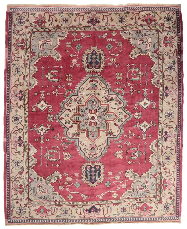 Full overhead view of the vintage red Anatolian rug with a central medallion on a white background