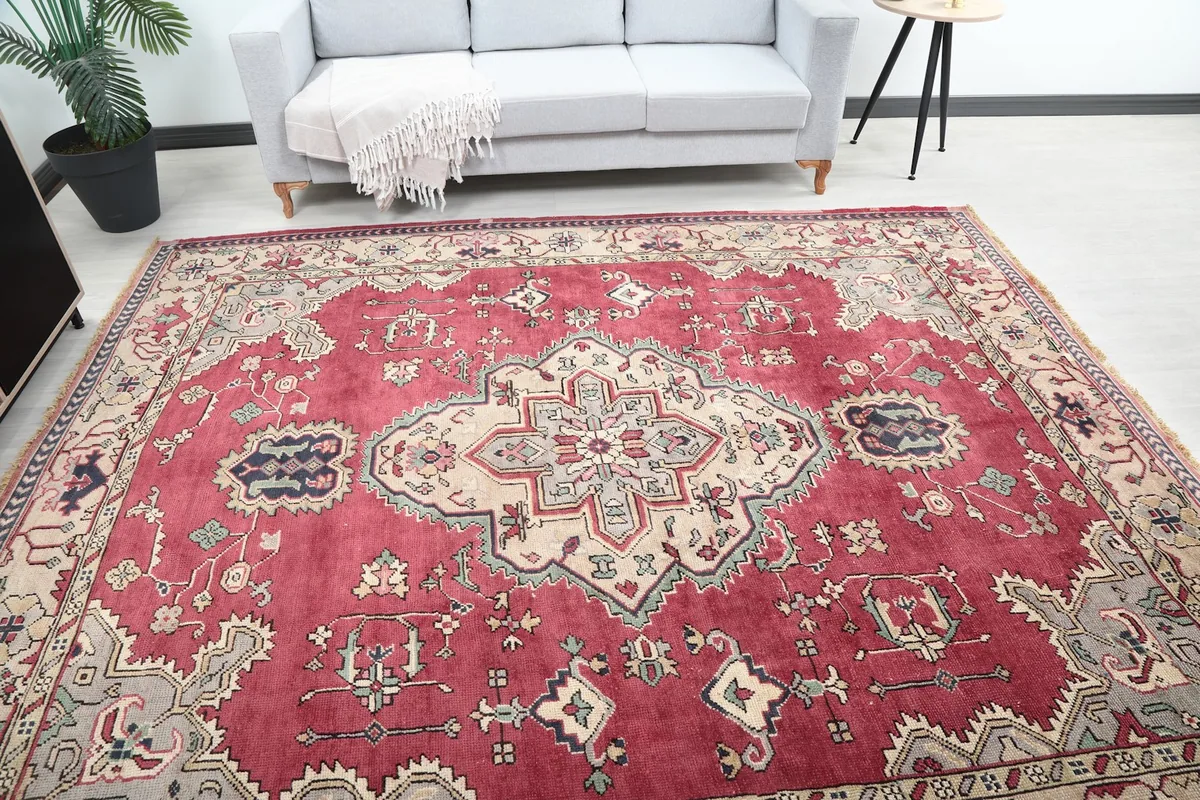 Wide angled view of the red rug placed in a living room setup with a gray sofa