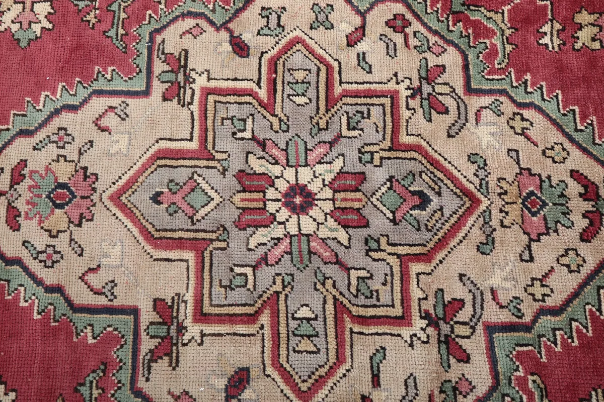Close-up of the central medallion design with red, beige, gray, and navy colors