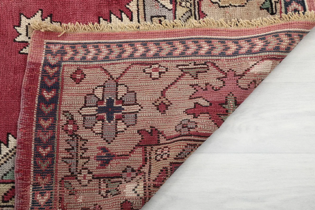 Close-up of the rug's reverse side and fringe, indicating hand-knotted construction