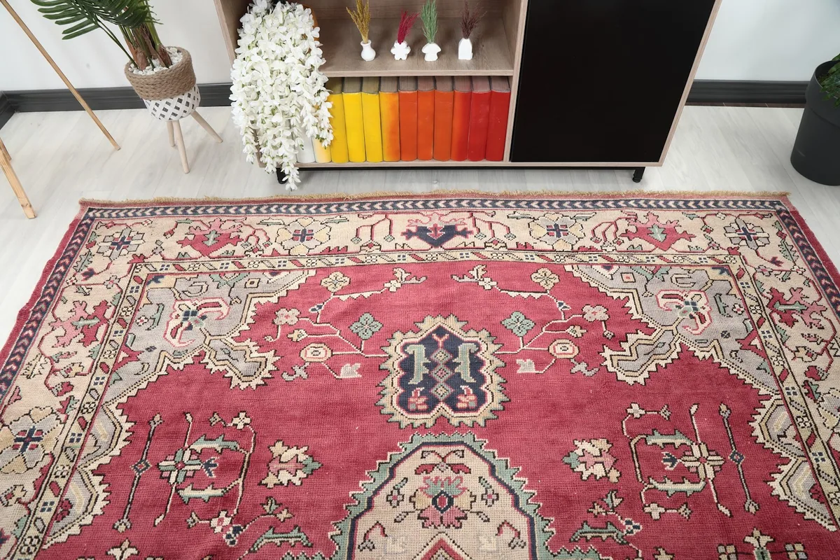 Overhead view of a section of the red rug, showing the upper half of the design