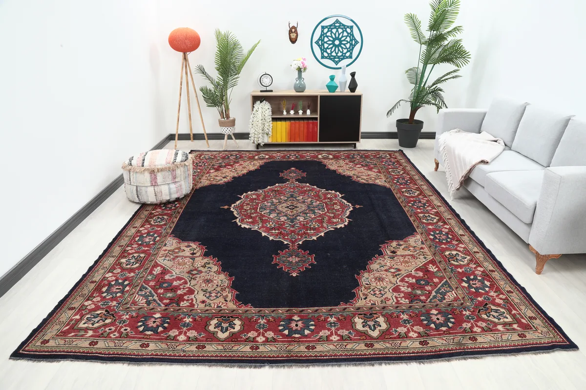 Navy Medallion Anatolian Rug showcased in a bright living room setup with a gray sofa and plants.