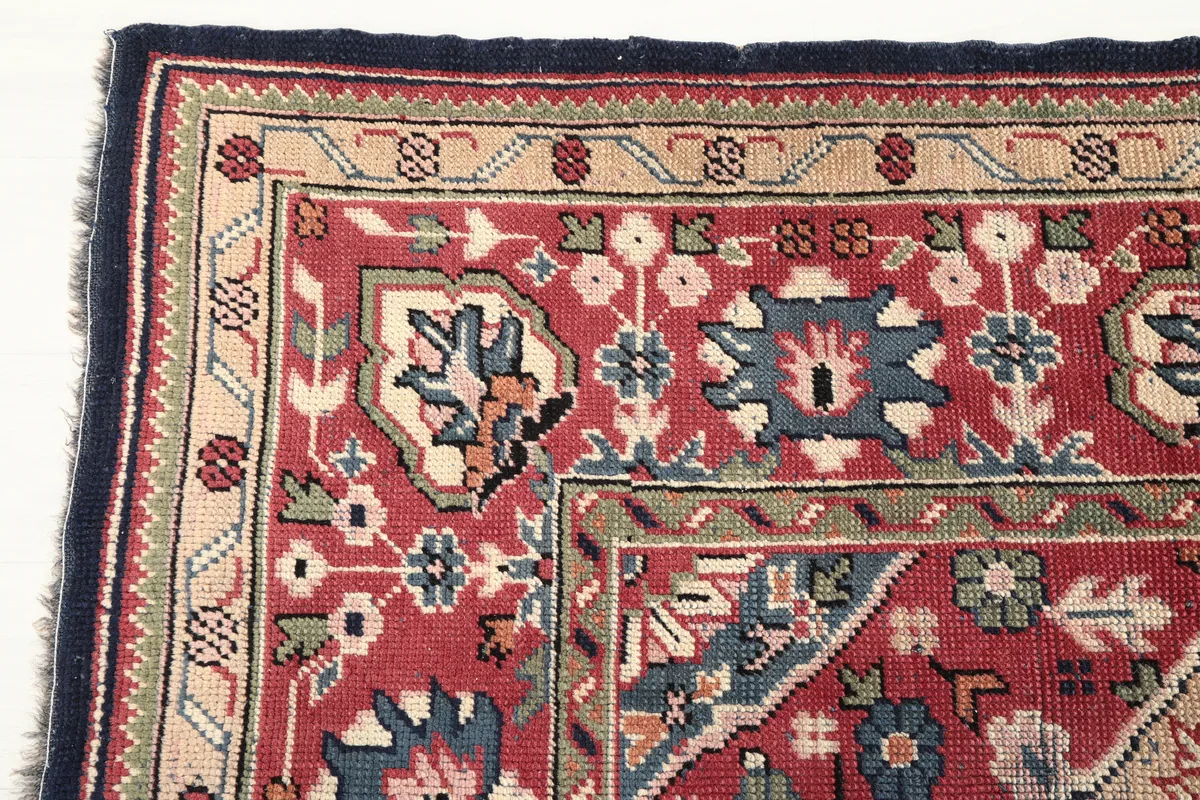 Detail of the border design on the Navy Medallion Anatolian Rug, featuring red, tan, and green patterns.
