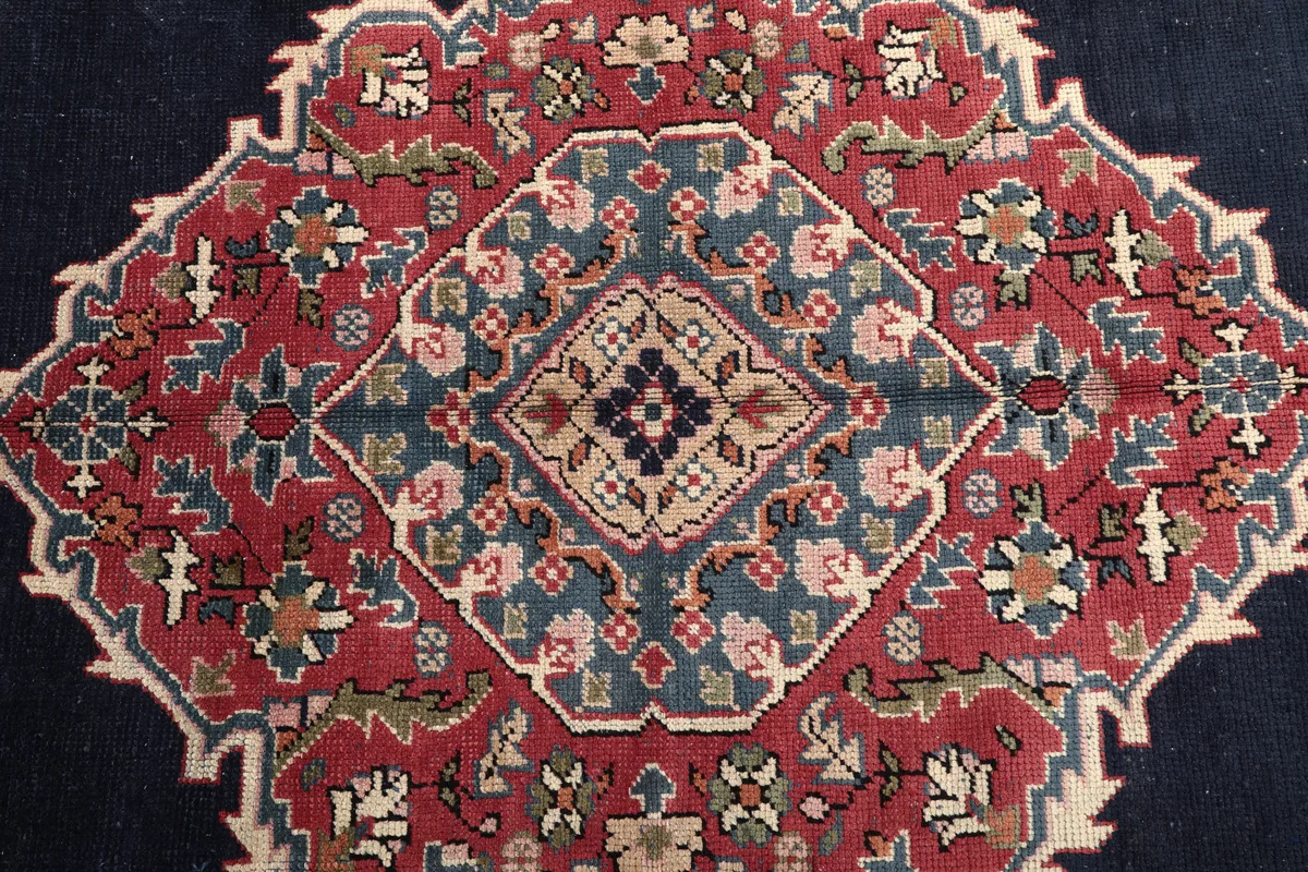 Detailed view of the medallion's heart on the Navy Medallion Anatolian Rug, with blue, red, and tan elements.