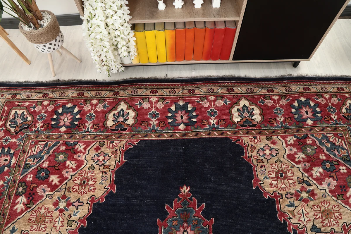 Detailed shot of the upper border of the Navy Medallion Anatolian Rug, with its red and tan motifs.