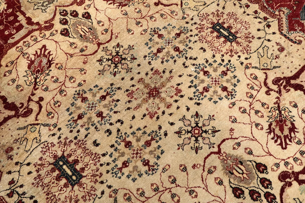 Detailed view of the delicate floral patterns within the rug's beige medallion