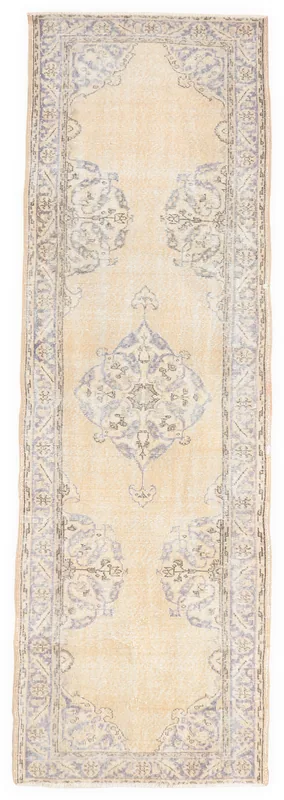 Full overhead view of the beige and blue vintage Anatolian runner rug on a white background.