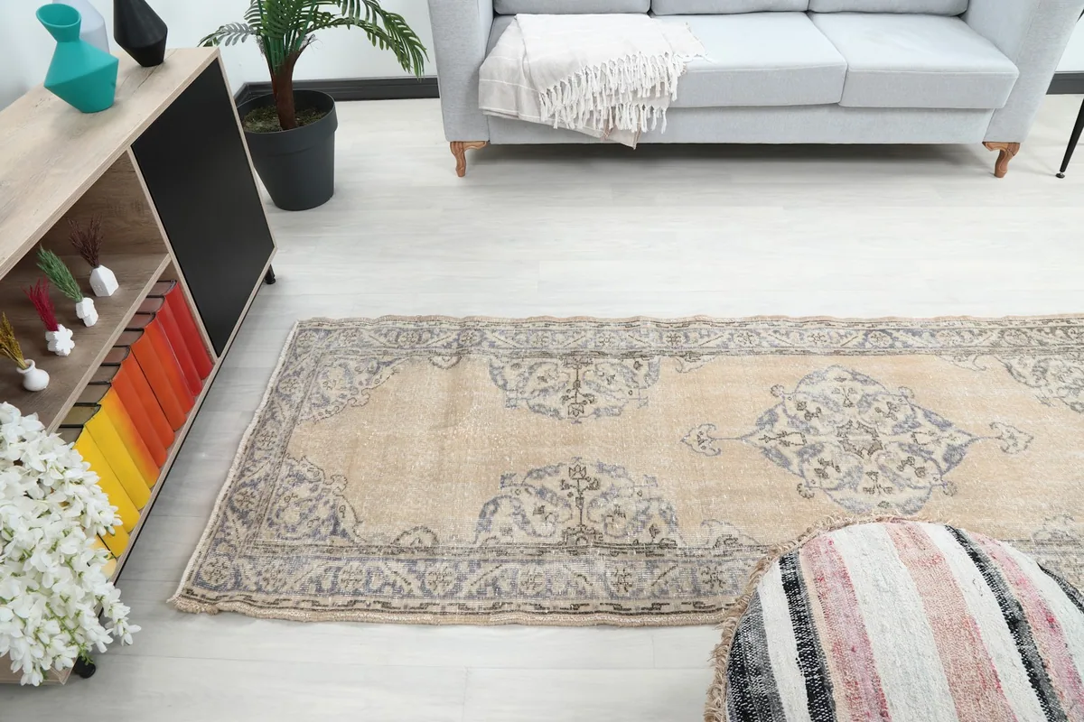 Wider view of the runner rug in the living space, showing its full length next to a sofa.