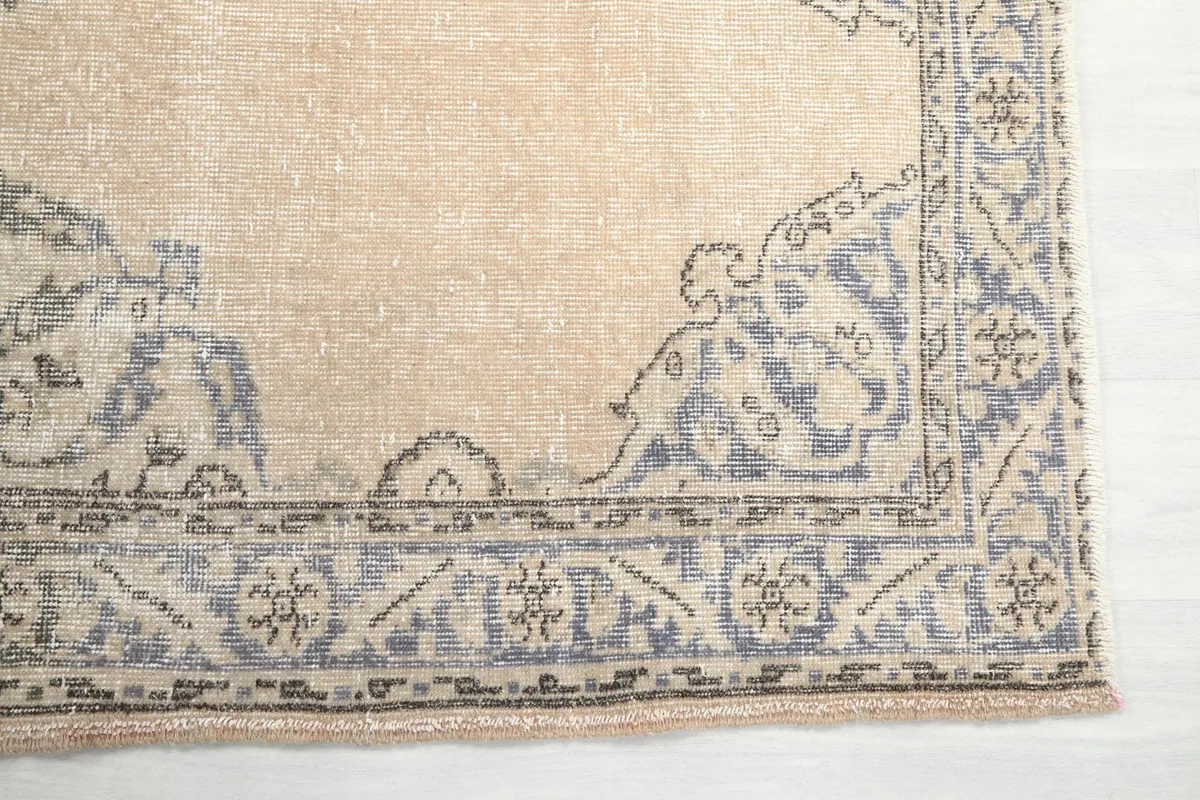 Detail view of the intricate blue and gray geometric border design of the vintage runner rug.