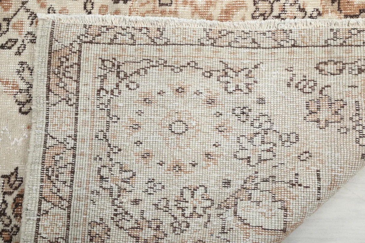 Close-up of the Cream Rust Medallion Anatolian Rug's back, revealing the intricate knotting and fringe.