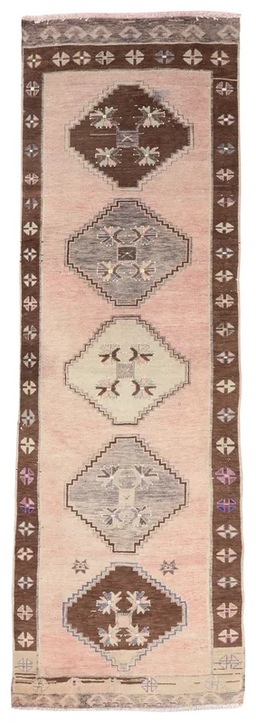 Full top view of the vintage Anatolian runner rug with rose field and brown geometric patterns