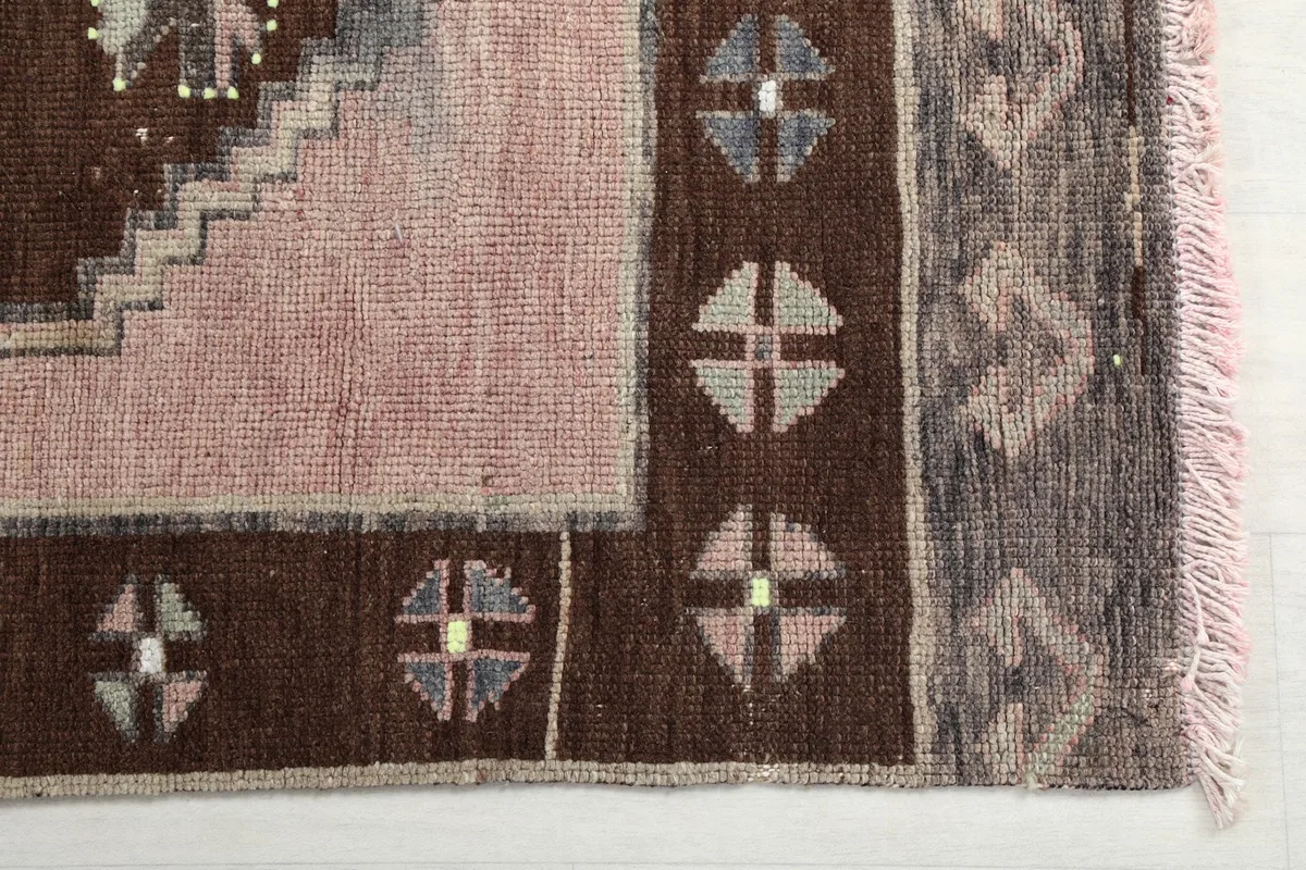 Close-up of the rug's corner, showing the brown border and subtle color variations
