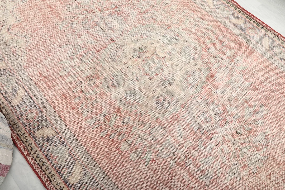 Close-up of the faded rose central field showing subtle patterns and vintage wear