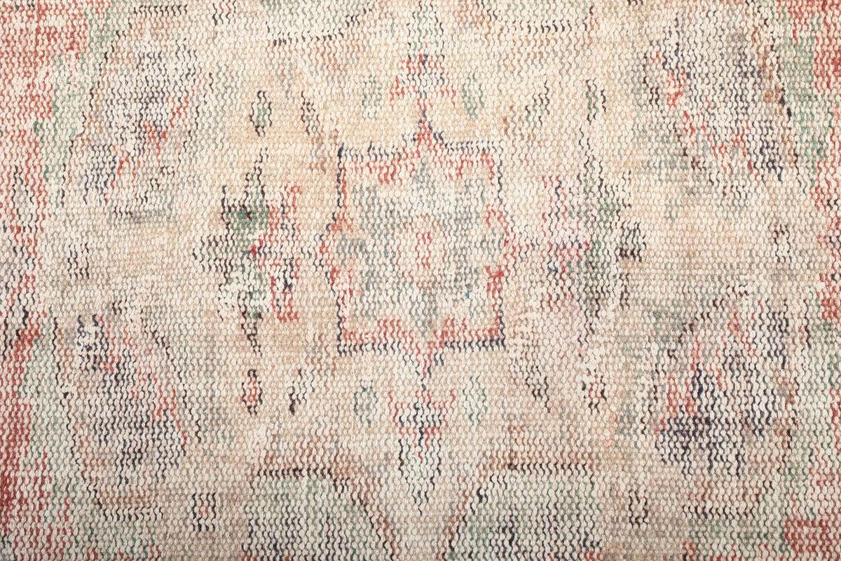 Texture close-up of the low wool pile showing the hand-knotted construction and color variations
