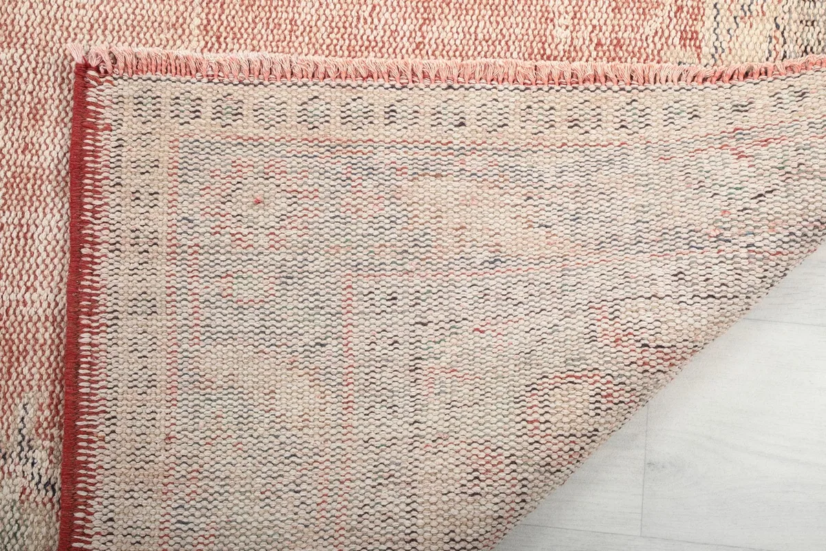 Underside of the hand-knotted wool rug, showing the cotton foundation and tight weave