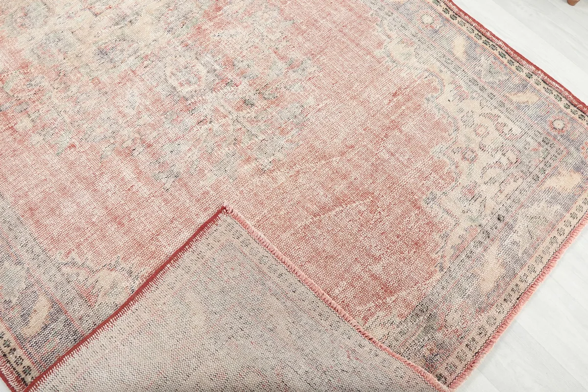 Corner of the rug folded back to reveal the cotton foundation and hand-knotted reverse