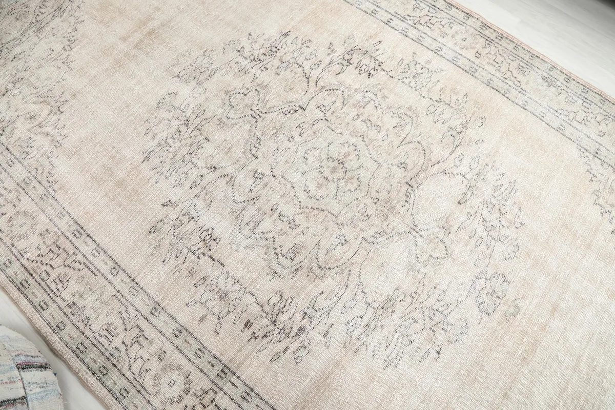 Detailed view of the central medallion and field patterns on the ivory rug
