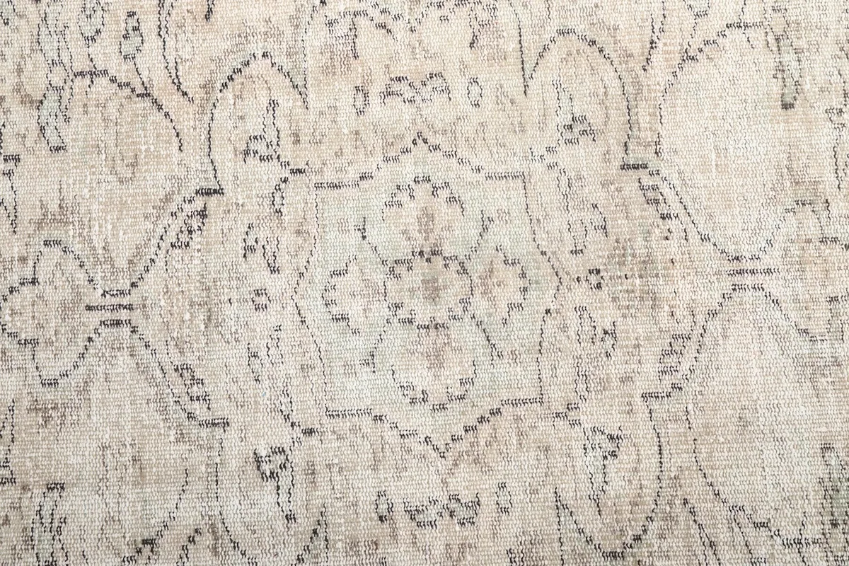 Close-up of the intricate gray floral and geometric motifs within the rug's field