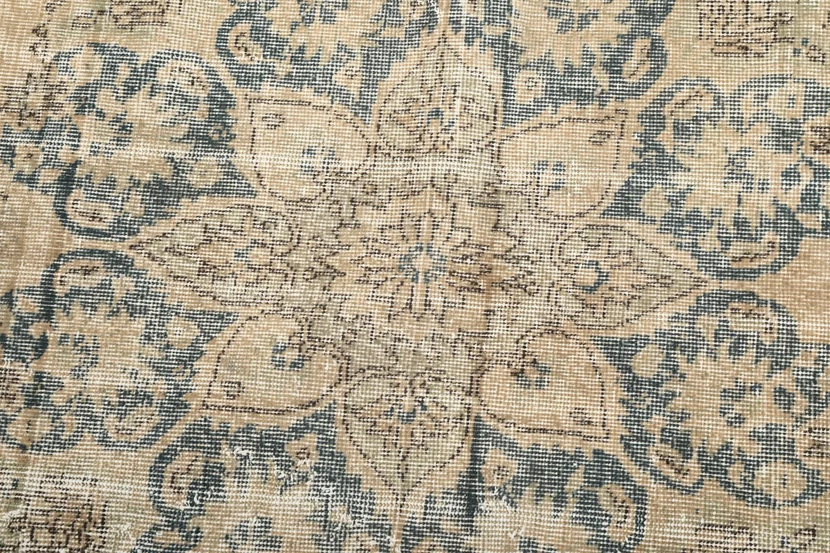 Close view of the hand-knotted wool pile and intricate blue floral design