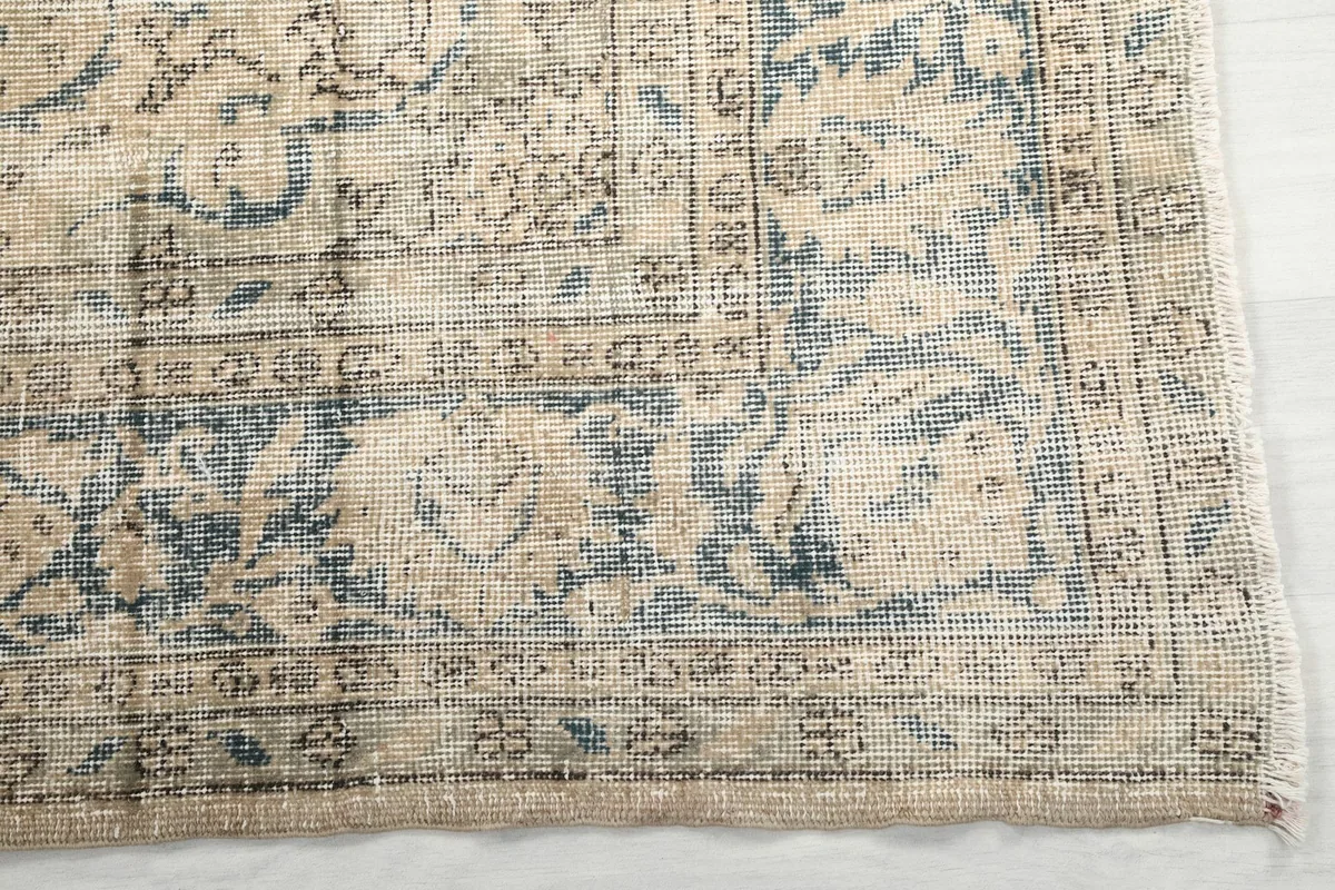 Detail of the outer border and corner with faded blue geometric patterns