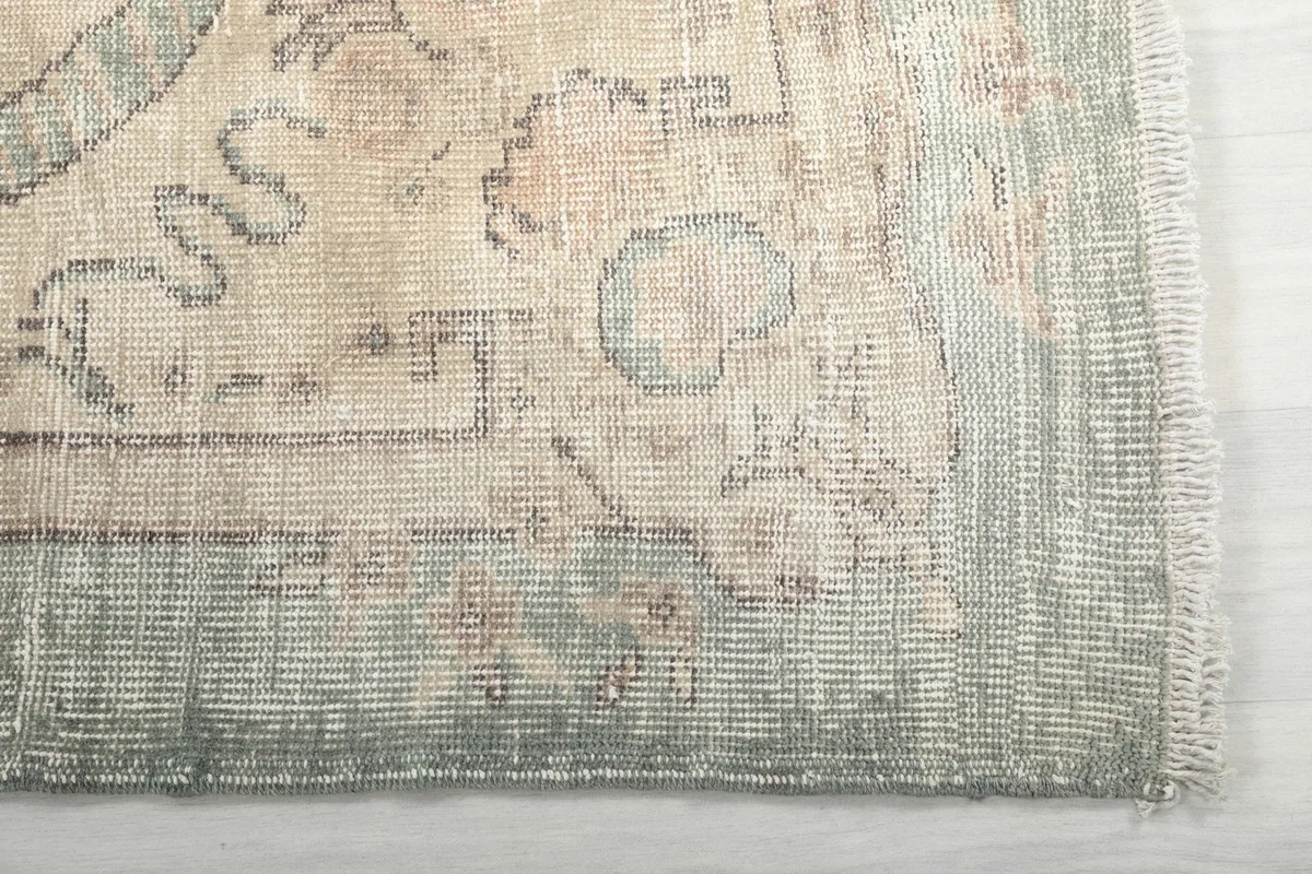 Detail of the green border and corner motifs with visible fringe