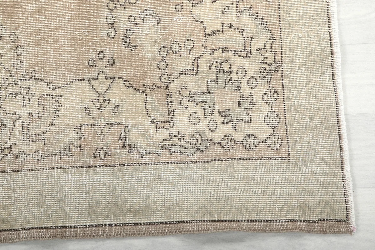 Detailed view of the rug's border and corner, highlighting distressed patterns