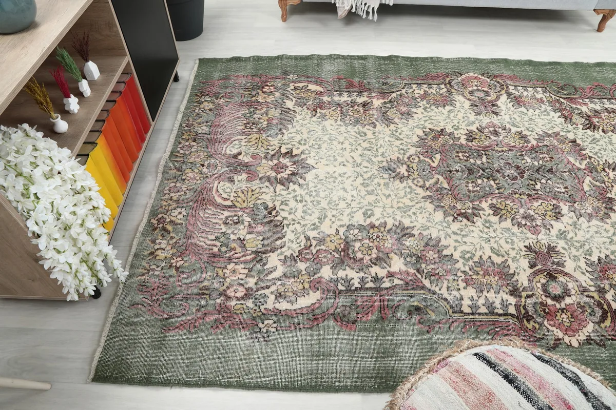 Wide angle showing the rug's length in the room, next to a striped ottoman