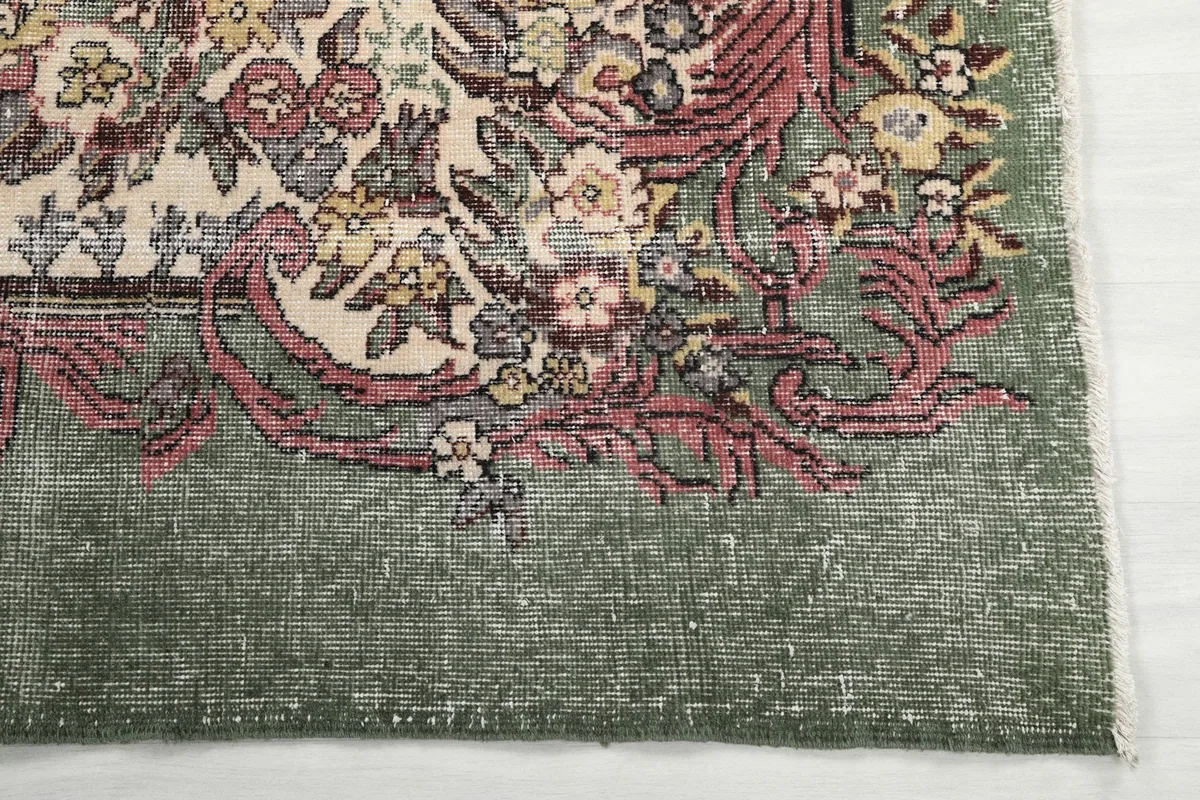 Detailed view of the olive border and the faded rose and ivory patterns